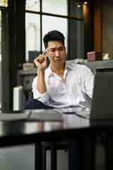 Focused Asian businessman planning his project while sitting in a coffee shop.