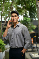 A man is talking on the phone with someone while standing outside of the building.