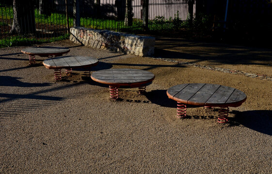 trampoline in the shape of a circle of planks. there are red steel springs between the ground and the plate. It is possible to jump from one to the other low above the ground,threshing , covered