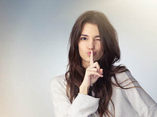 Woman, studio portrait and secret with finger on mouth for beauty deal, wink eye or icon for...