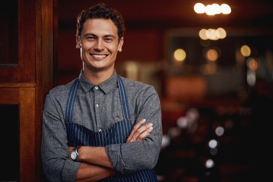 Portrait, man and small business owner of cafe, restaurant or pub with a smile for career pride. Male entrepreneur person as manager, barista and waiter or bartender at door for shop welcome greeting