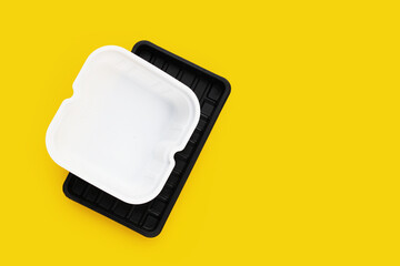 Plastic food packaging on yellow background.