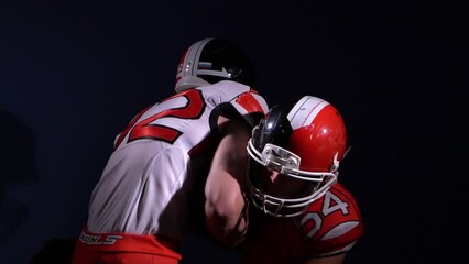 Two american football players fighting while game match. One footballer catch a ball and run. Extreme sport concept. Agressive and masculine style.