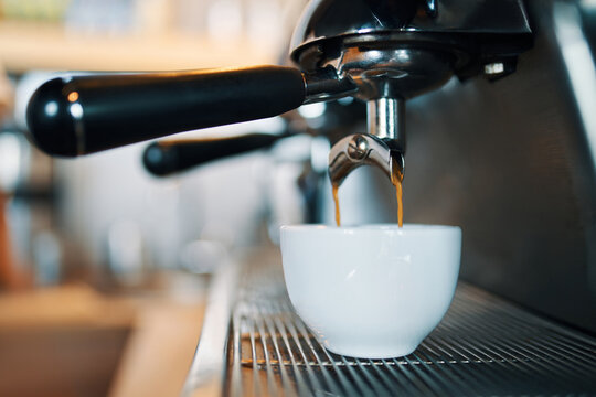 Industrial espresso machine pouring fresh coffee