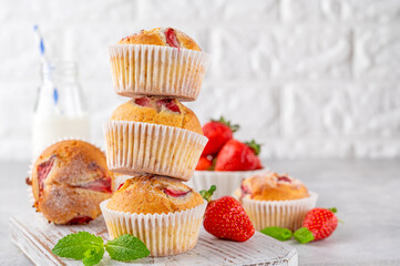 Homemade strawberry muffins or cupcakes on a board on a gray background. Selective focus. Copy space