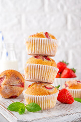 Homemade strawberry muffins or cupcakes on a board on a gray background. Selective focus. Copy space