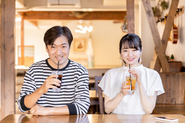Fototapeta na wymiar 喫茶店・飲食店・カフェでデートする楽しそうにおしゃべりするアジア人のカップル・夫婦 