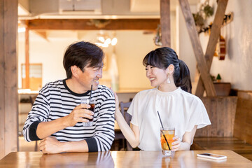 Fototapeta na wymiar レストラン・飲食店・カフェでデートする楽しそうにおしゃべりする男女 