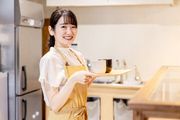 カフェ・レストラン・飲食店で働くウェイトレス・ホールスタッフのアルバイトをする女性
