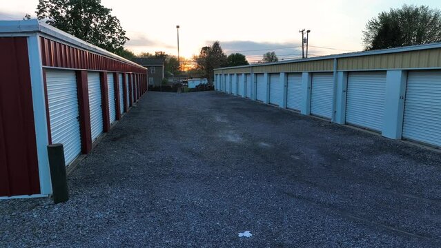 Aerial orbit of self storage units in America. Sunset over gravel lot holding warehouse temporary storage units. Privately owned and rented.