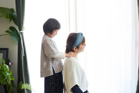 母の肩を揉む日本の娘