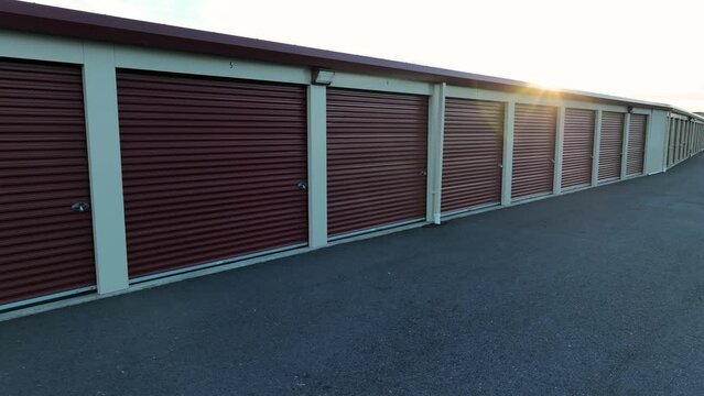 Aerial shot of self-storage units in USA. Sunset over paved storage warehouse facility. Sunburst in lens.