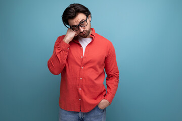 upset 35 year old brunette millennial man with gorgeous hair in a red shirt