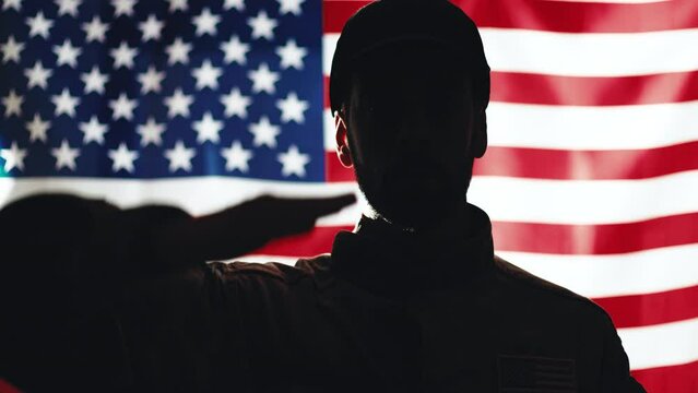 American soldier salutes in front of the American flag