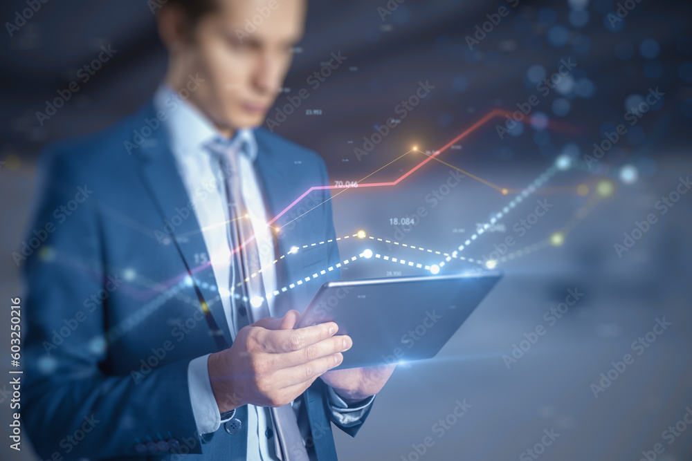 Poster Attractive businessman using tablet with glowing business chart lines with bokeh sparkles on blurry background. Annual report, finance and success concept. Double exposure.