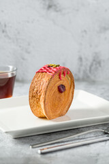 New York roll or round croissant with marmalade with tea on stone table