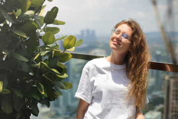 Portrait of young happy woman, beautiful girl outdoors on terrace at summer sunny day enjoy day,...