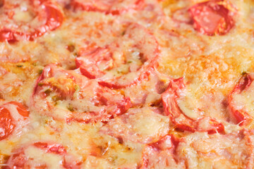 Pizza with tomatoes sausage and cheese closeup.