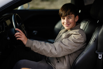 Teenager boy sit in muscle car. Young teen driver. © AS Photo Family