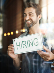 Man with hiring sign, window with job opportunity advertising, happy waiter or barista in portrait....