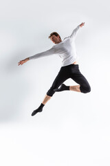 Fototapeta na wymiar Athletic Modern Ballet Dancer. Contemporary Art Ballet With Young Flexible Athletic Man In Studio On White Background.