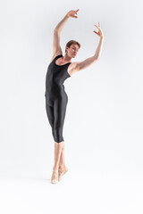 Modern Ballet Dancing.  Contemporary Art Ballet of Young Caucasian Flexible Athletic Man in Black Suit Dancing in Studio Over White