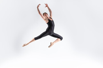 Fototapeta na wymiar Ballet Dancer Young Caucasian Athletic Man in Black Suit Posing Dancing in Studio On White.