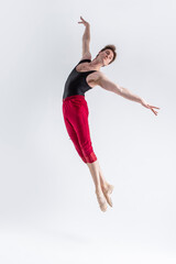 Malea Dancer. Contemporary Art Ballet With Young Flexible Athletic Man Posing in Flying Dance Pose in Studio on White