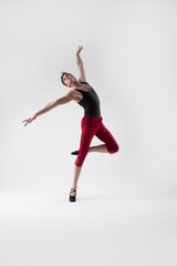 Obraz premium Ballet Sport Ideas. Contemporary Ballet of Flexible Athletic Man Posing in Red Tights in Dance Pose With Hands Lifted in Studio