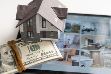 house model and banknote on tablet, buy house online concept.