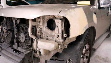 pickup truck front bumper damaged by accident Parked waiting for repairs in a large car repair. that has standards for repairing body paint to cars by expert technicians to return to normal use