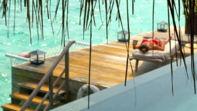 Woman reading in luxury pool villa
