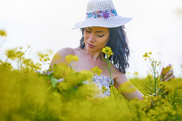 portrait of a brunette woman in a rapeseed field in spring