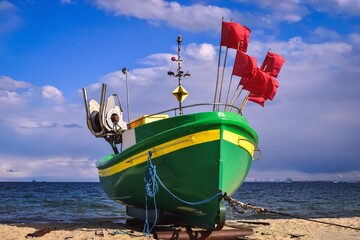 Beautiful colorful boat on the seashore. Photo taken at the Baltic Sea in Gdynia Orlowo, Poland.