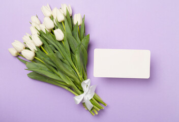 Greeting card mockup with tulips on color background, top view