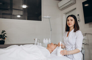 Happy calm relaxed young woman or teenage girl lying on soft towel in beauty parlor or spa salon