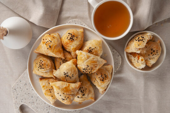 Puff hot samsa with pumpkin and hot tea. Table setting in European style.