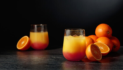 Tequila sunrise cocktail with ice and grenadine.