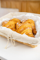 Freshly baked croissants in a woven basket