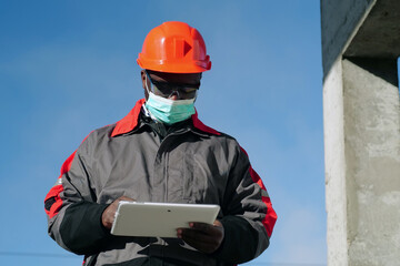 African american workman holds in hands white tablet computer
