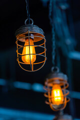 bright orange lamps in a dark ceiling. a burning electric light bulb screwed into the socket against a dark background