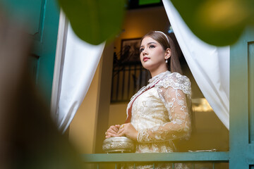 Beautiful young Asian woman wearing traditional classical Thai dress costume and The ancient...