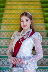 Beautiful young Asian woman wearing traditional classical Thai dress costume and The ancient...