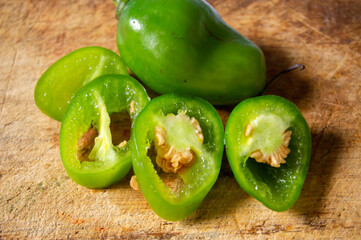 sliced ​​freshly harvested jalapeno green chilies on a chopping board background