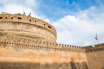 Detail of the towers and walls of the Mausoleum of Hadrian, usually known as Castel Sant'Angelo. Waving an Italian flag. - obrazy, fototapety, plakaty
