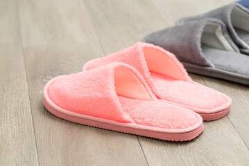 Pink and gray slippers on the floor. Home shoes on the linoleum floor