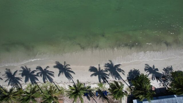 Footage of top view from drone of sea water waves to the white beach. Travel on holiday on Koh Mook Island.