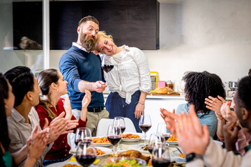 Young couple announces engagement and future wedding in a dinner with friends, international group of friends celebrate and toast together