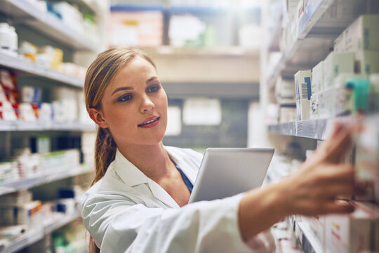 Medicine, woman pharmacist with tablet and looking for prescription in an isle at the pharmacy or clinic. Healthcare, pharmaceutical and female person search for medication with digital device