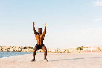 Fototapeta na wymiar Fitness training outdoors. Handsome African man doing exercises outside. Muscular man tarining.